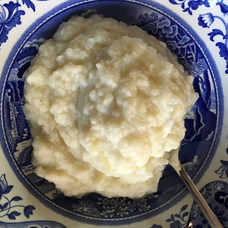 mashed cauliflower in blue white porcelain serving bowl