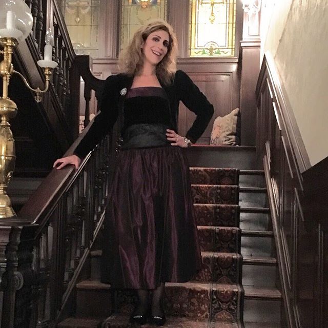 Lauren Dimet Waters in burgundy and black 80s dress on staircase