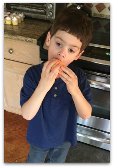 boy-eating-an-apple-in kitchen