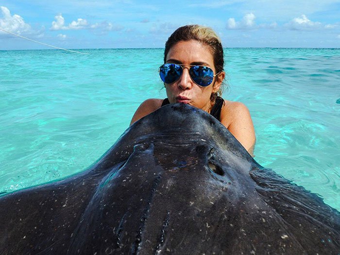 Permission To Hustle cruise experience woman sunglasses kissing a stingray