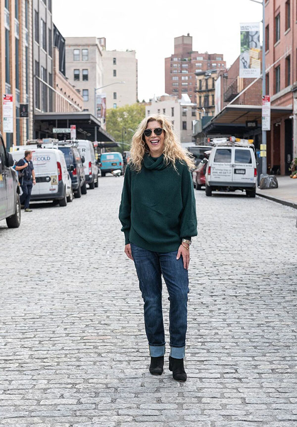 Cabi Clothing Fall 2018 Collection woman in street in green sweater and blue jeans