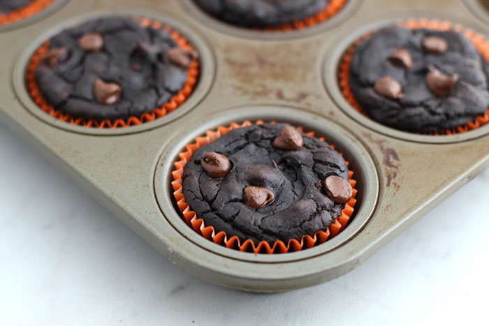 Healthy Pumpkin Chocolate Brownie Muffins in pan orange muffin cups