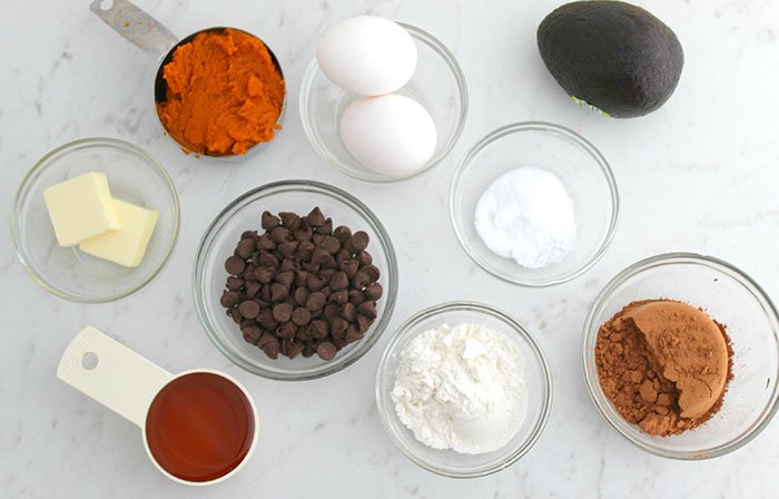 Healthy Pumpkin Chocolate Brownie Muffins ingredients on a marble counter eggs butter flour