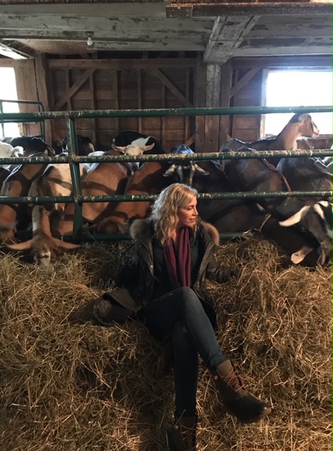 Beekman 1802 lauren dimet waters seated on straw with farm goats 