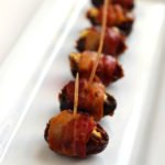 finished bacon wrapped dates stuffed with goat cheese on a platter