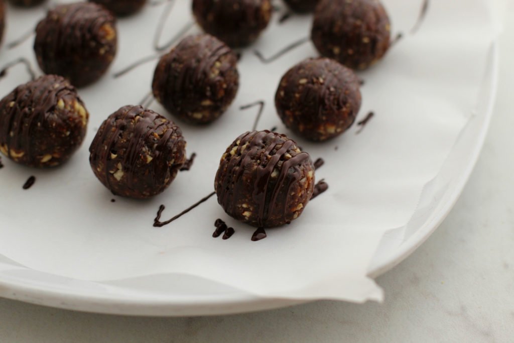 Gingerbread Energy Bites chocolate drizzled on wax paper