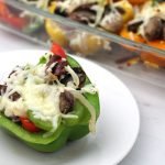 Keto Philly Cheesesteak Stuffed Peppers colorful peppers in glass pan with serving on white plate