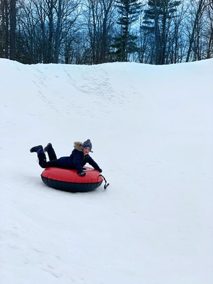 Little boy snow tubing in the snow