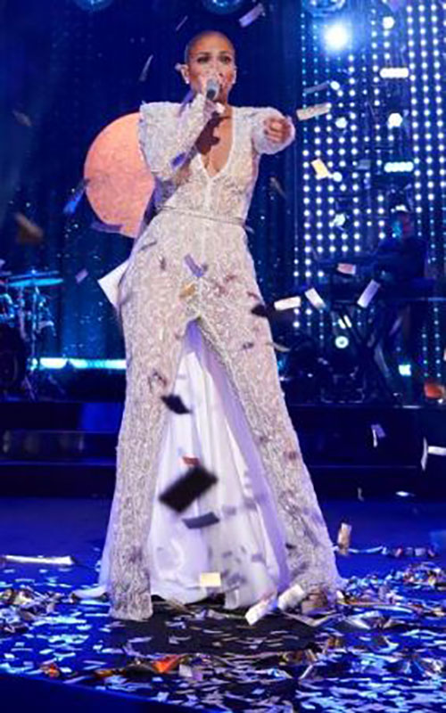 J Lo singing on stage in white Galia Lahav lace pant suit with train