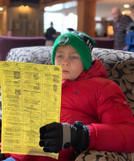 Boy reading a piece of paper in winter gear