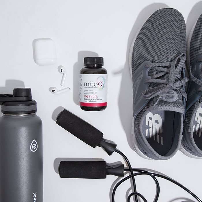 MitoQ bottle of supplements with grey gym shoes jumprope water bottle