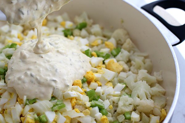 potato salad made with cauliflower mixing the salad