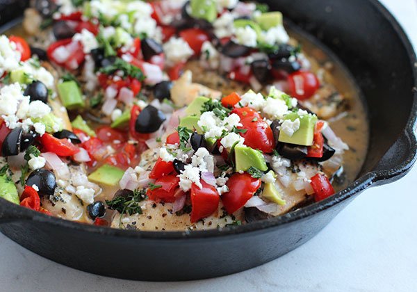 Mediterranean Chicken In a Skillet topped with avacados anf feta