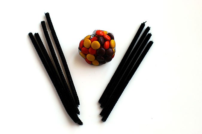 four black pipe cleaners in half with candy