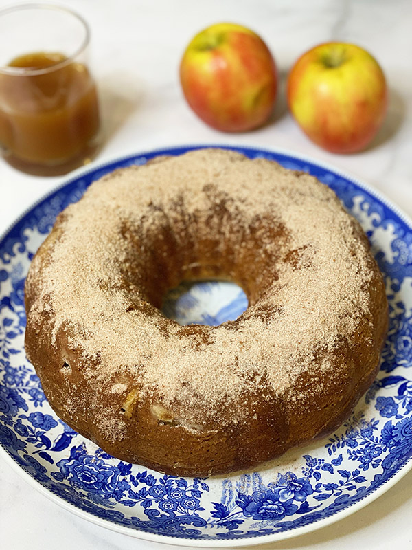 Apple Cider Cake onn blue plate with apples and cider fountainof30