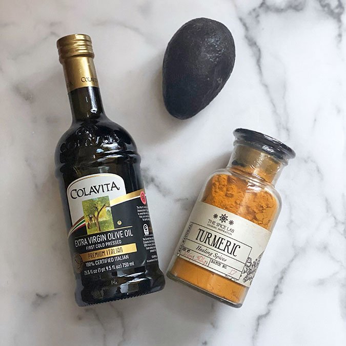 Face Mask ingredients olive oil tumeric avacado Colavita olive oil tumeric avacado on white marble fountainof30