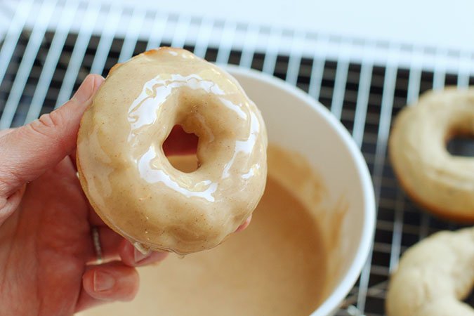 dipping apple baked donut into glaze fountaiof30