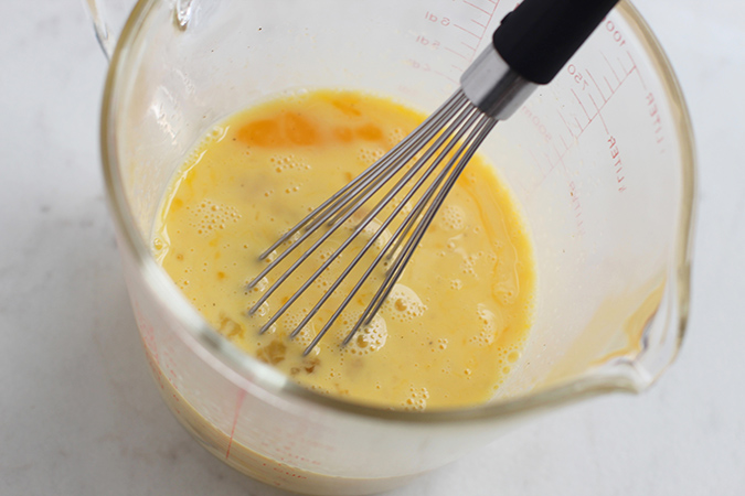 whisk and eggs in a measuring cup fountainof30