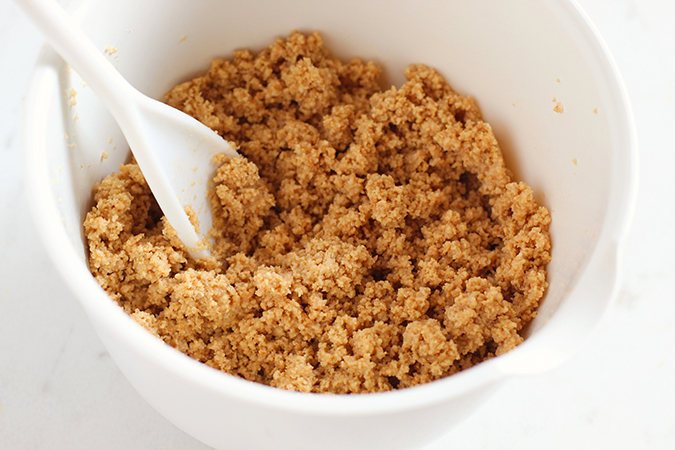 mixing cruahed cookiea and butter in a bowl fountainof30