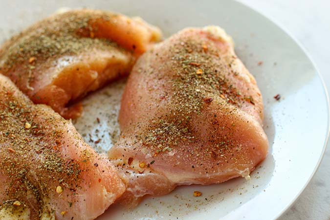 raw chicken breasts sprinkled with seasonings fountainof30