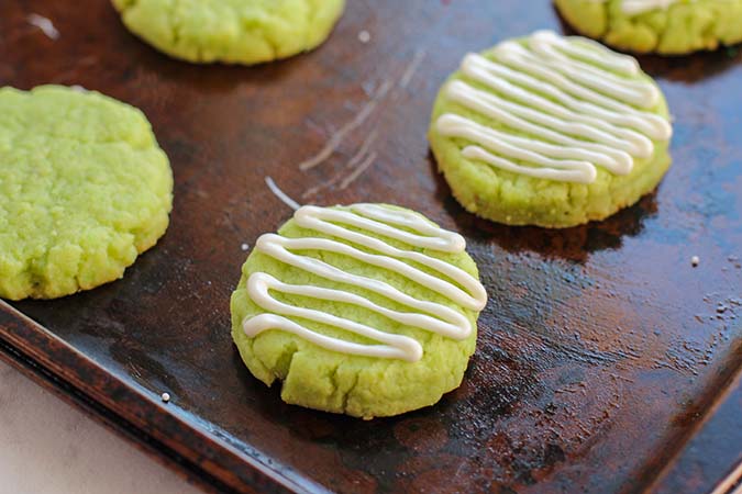 piped white chocolate icing on baked lime green cookies fountainof30