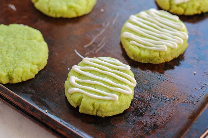 piped white chocolate icing on baked lime green cookies fountainof30
