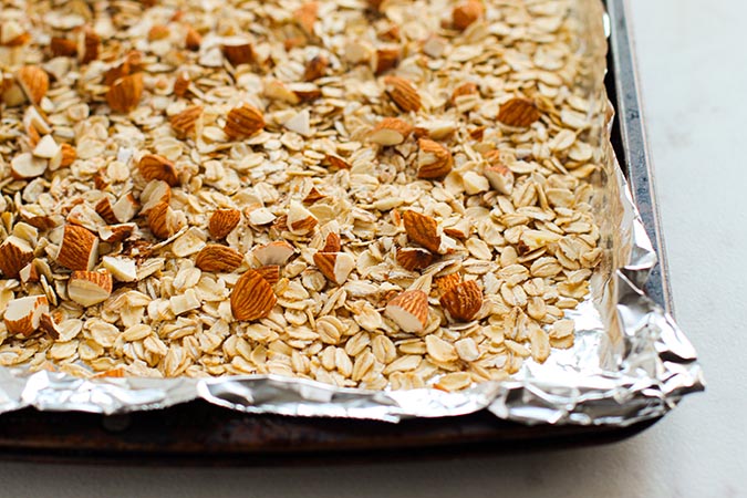 baked oats and chopped almonds to prepared baking sheet fountainof30