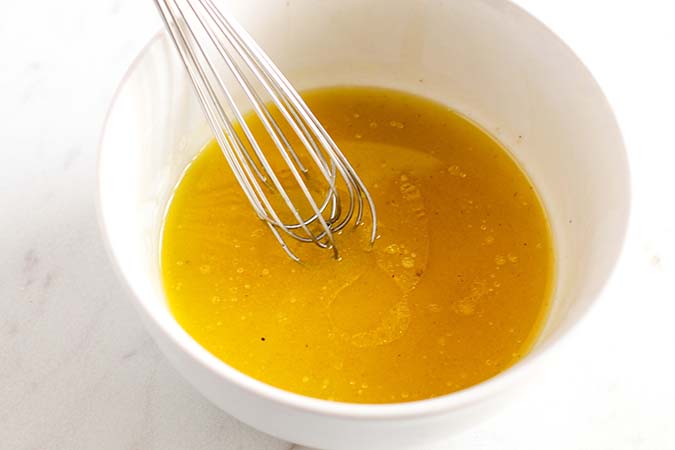 lemon vinaigrette dressing ingredients wisked in a bowl fountainof30