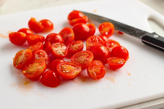 sliced grape tomatoes on cutting board fountainof30