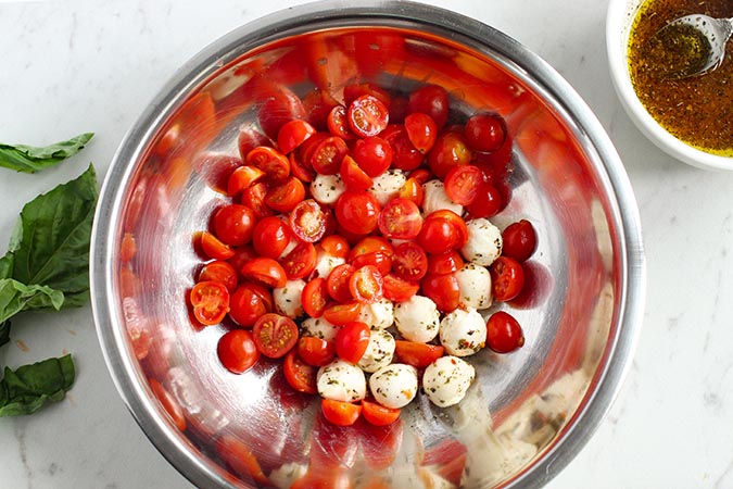 tomatoes and mini mozzarella balls in a mixing bowl fountainof30