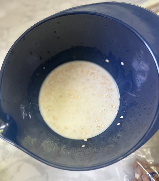 oats and almond milk in a small blue bowl fountainof30