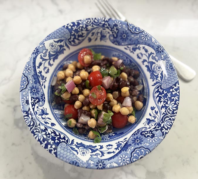 serving of healthy bean salad in bowl with fork fountainof30