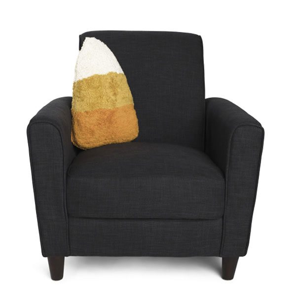 one candy corn shaped pillow on a chair