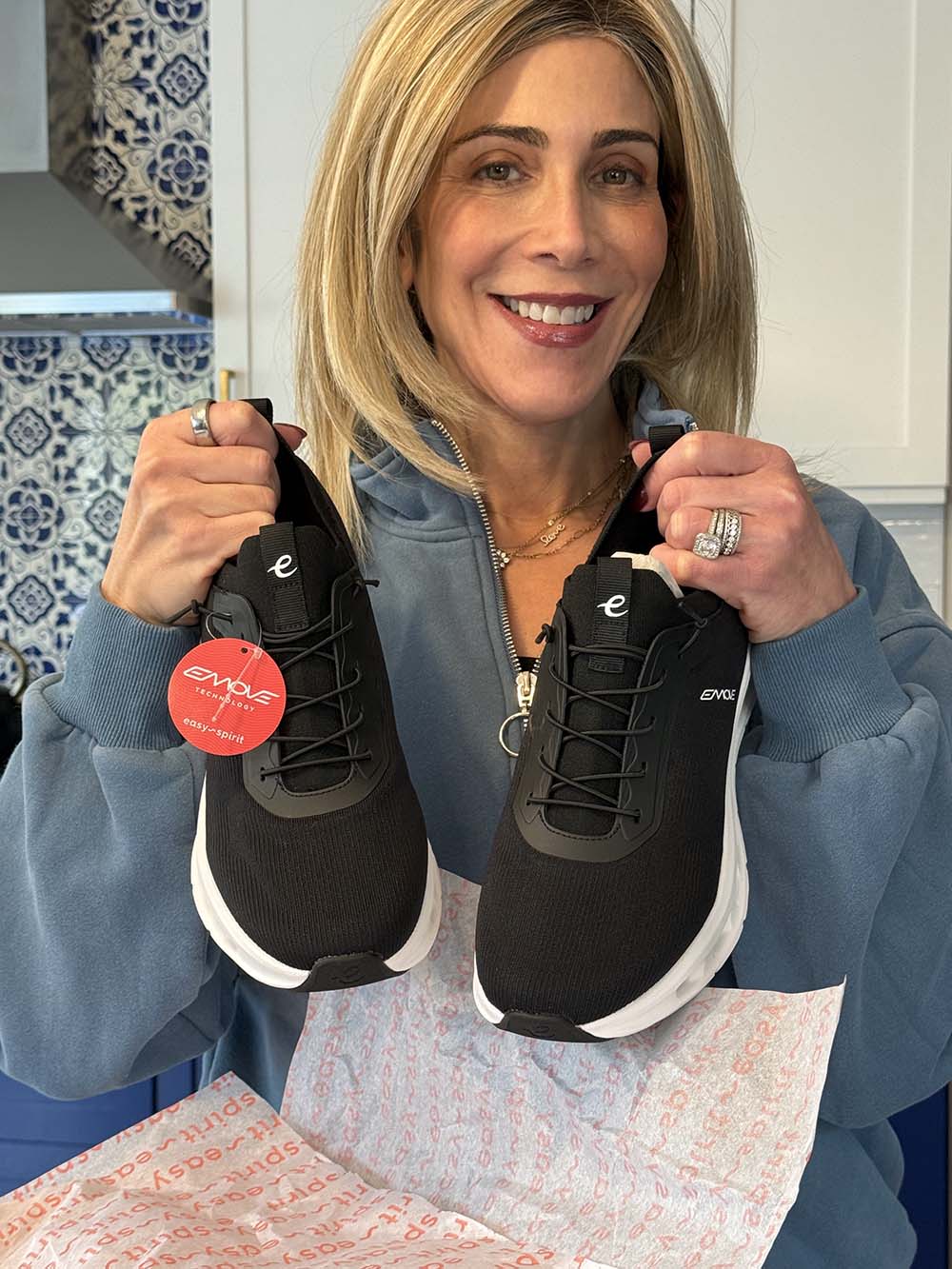 Lauren Dimet Waters holding black Easy Spirit x Denise Austin Reese sneakers fountainof30