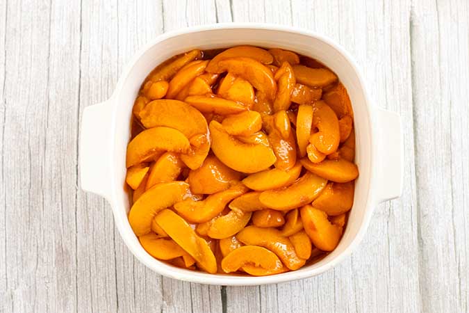 Peach filling in baking dish for peach cobbler recipe