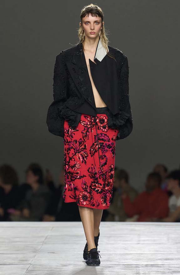 Dries Van Noten Spring 2026 runway showing black soft flat sneakers styled with a paisley midi skirt